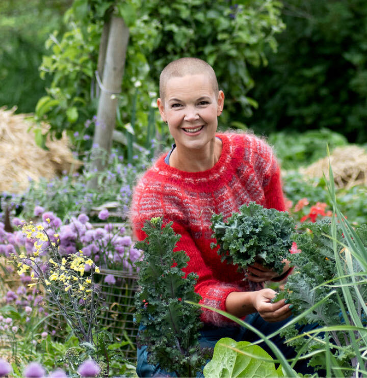 Sara Bäckmo mitt i en prunkande trädgård